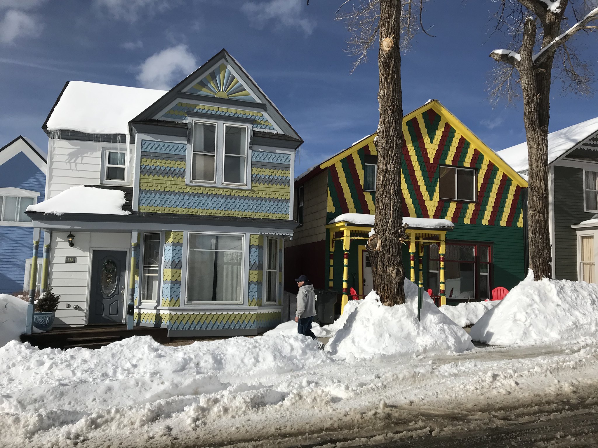 Two colourful houses on a snowy street